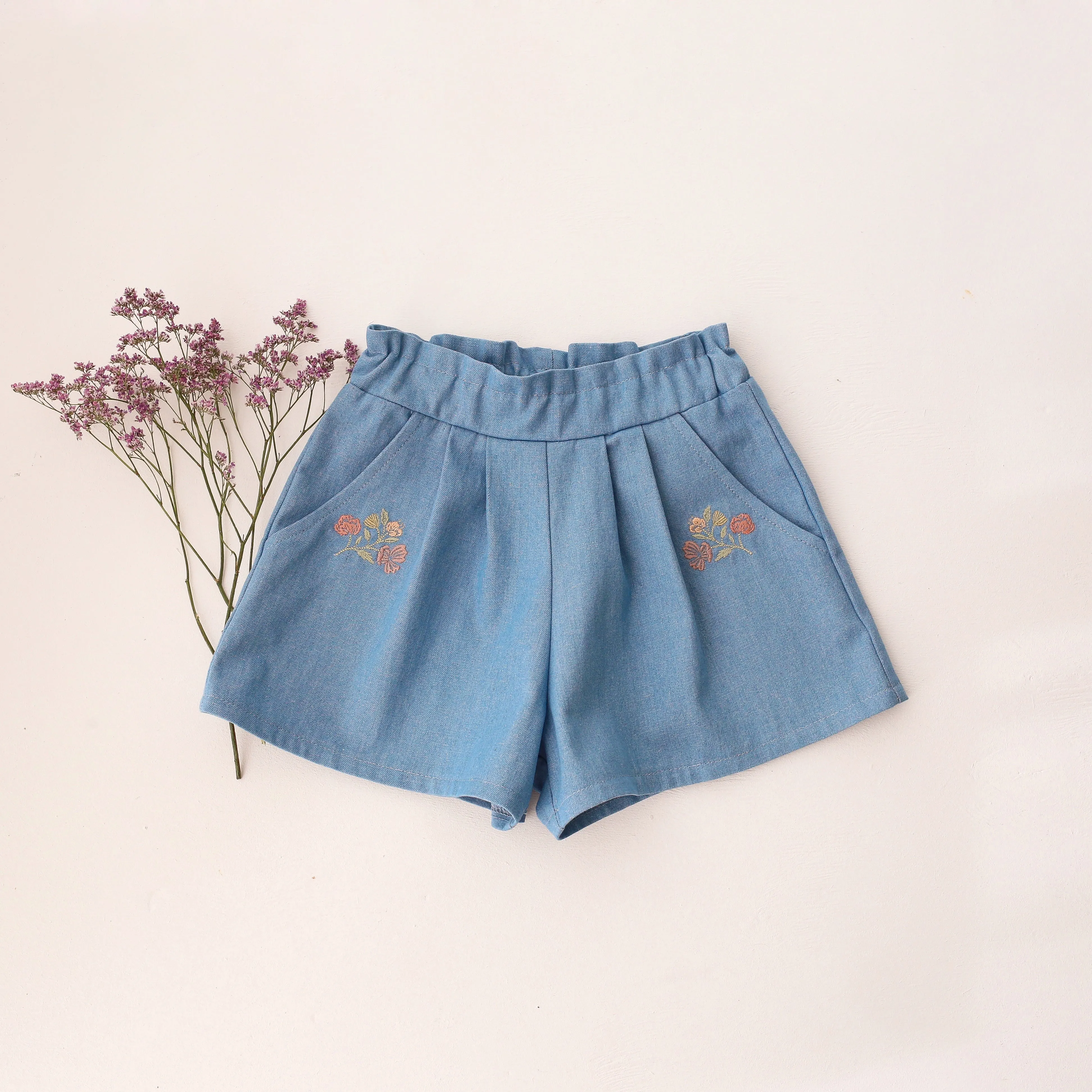 Light Blue Denim Paperbag Waist Shorts with "Wild Bells" Embroidery